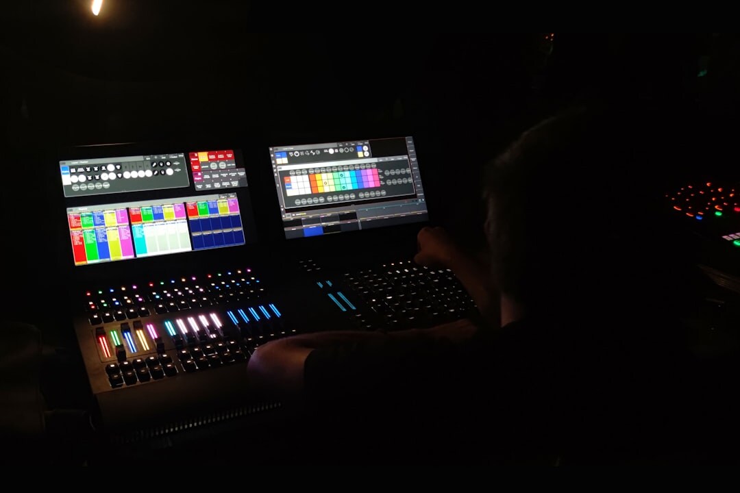 Video-Editorin an einem Colour-Grading-Arbeitsplatz mit mehreren Monitoren